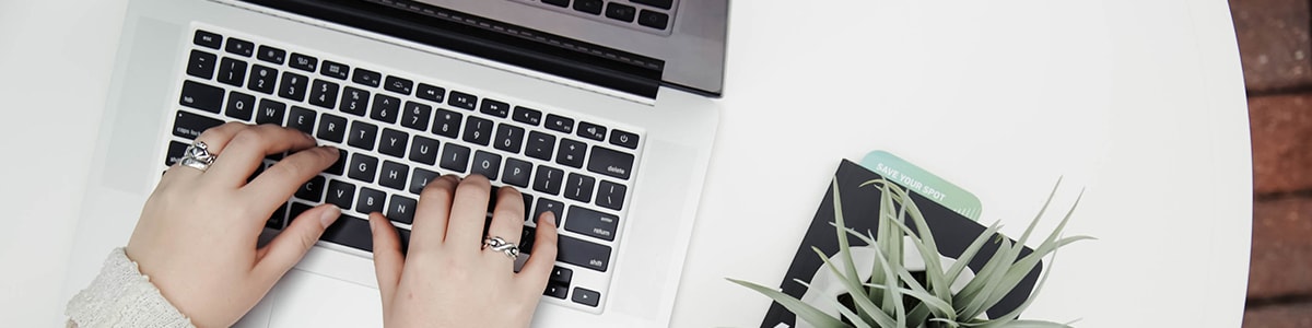 Hands typing on a laptop